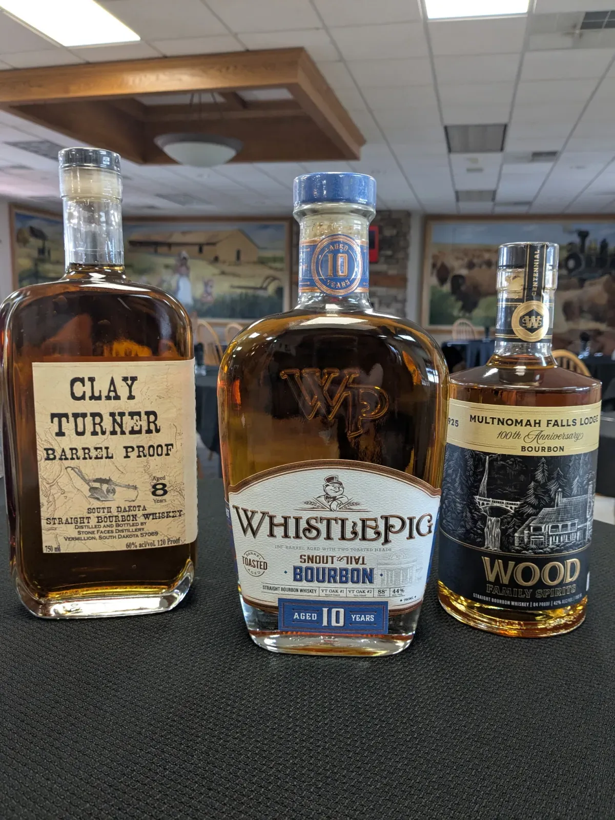 Three bourbon raffle prizes: Clay Turner Barrel Proof, WhistlePig 10 Year, and Wood Family Reserve