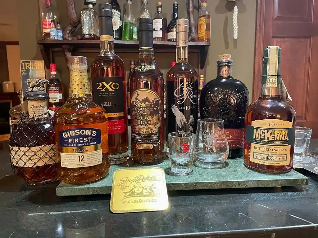 A selection of bourbon bottles and tasting glasses arranged on a bar counter.