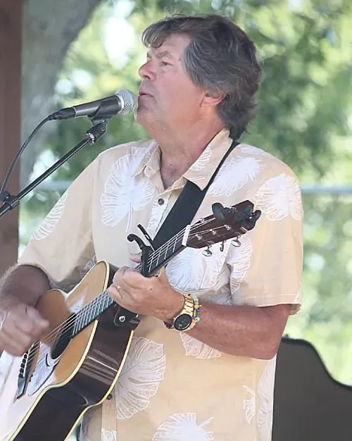 Paul Weidenbach singing and playing acoustic guitar on stage